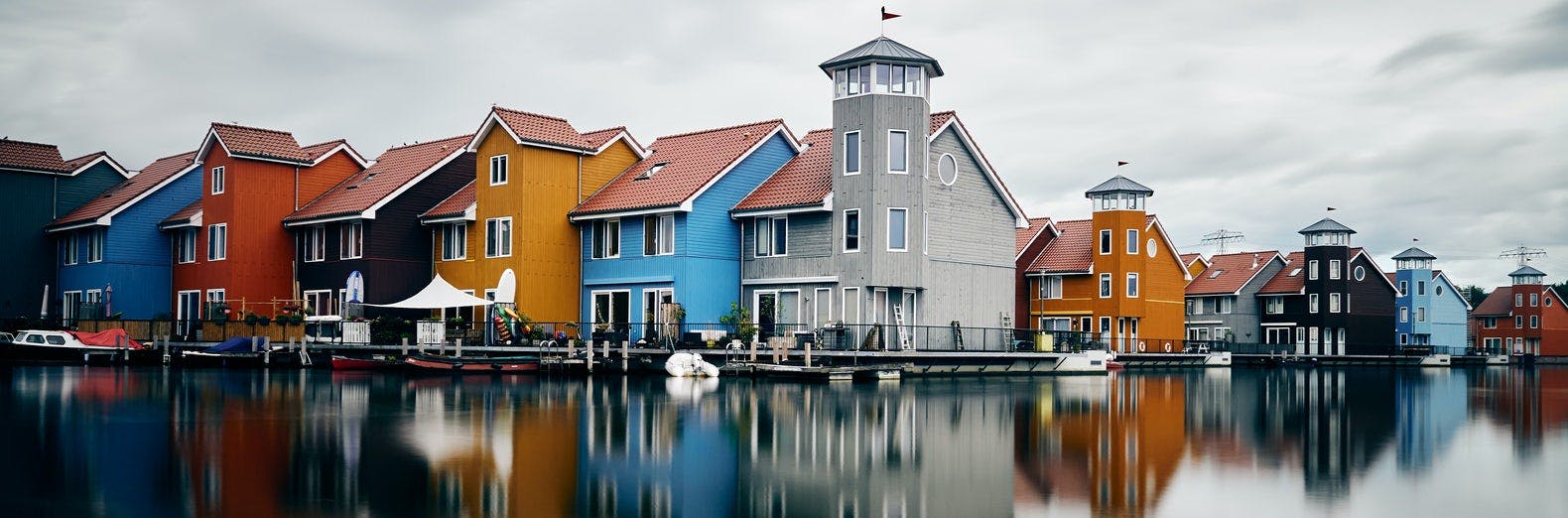 bunte Häuser am Wasser vor dunklen Wolken in Groningen