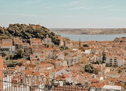 Aussicht über Lissabon von einem Aussichtspunkt in Alfama mit vielen Häuern und dem Meer