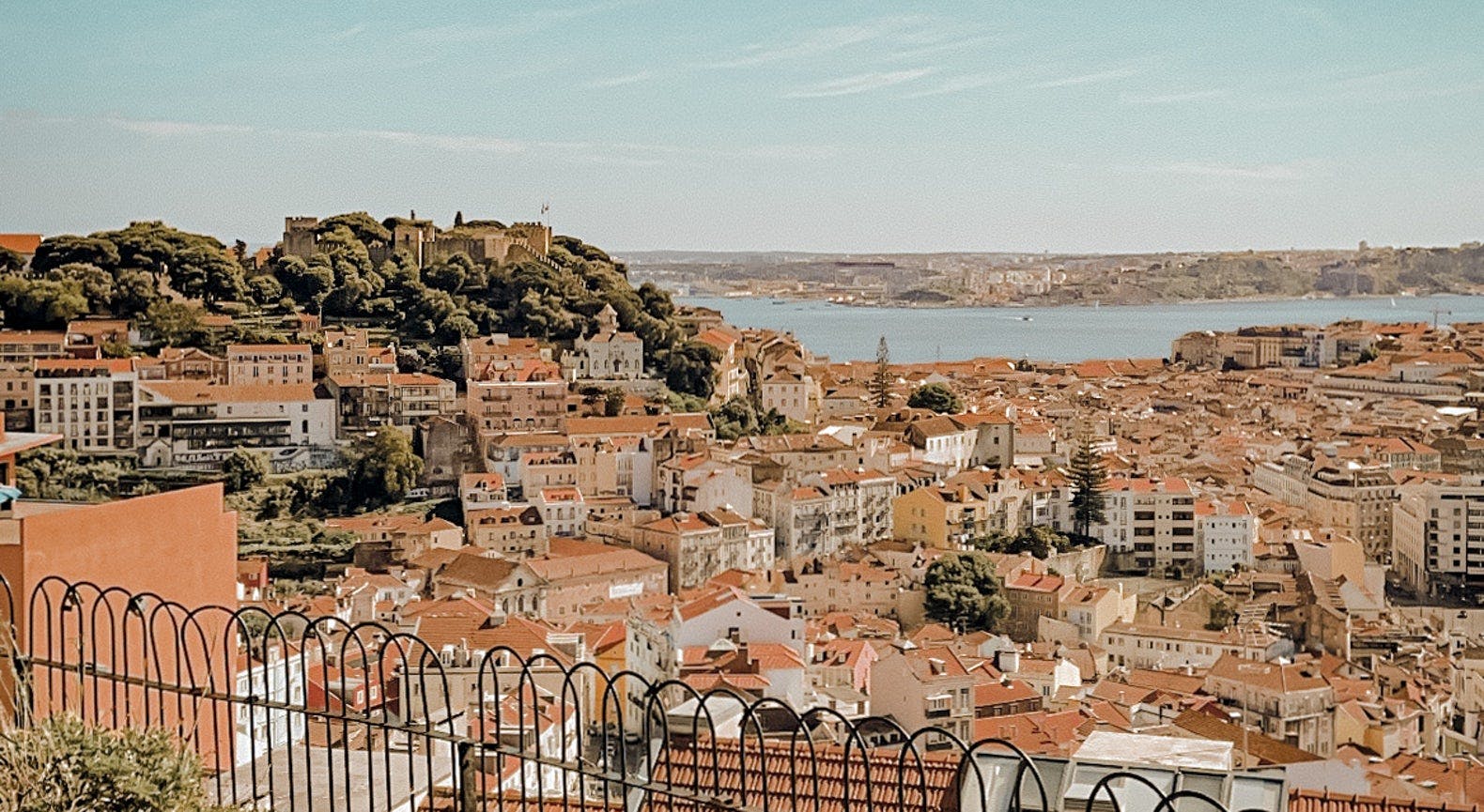 Aussicht über Lissabon von einem Aussichtspunkt in Alfama mit vielen Häuern und dem Meer
