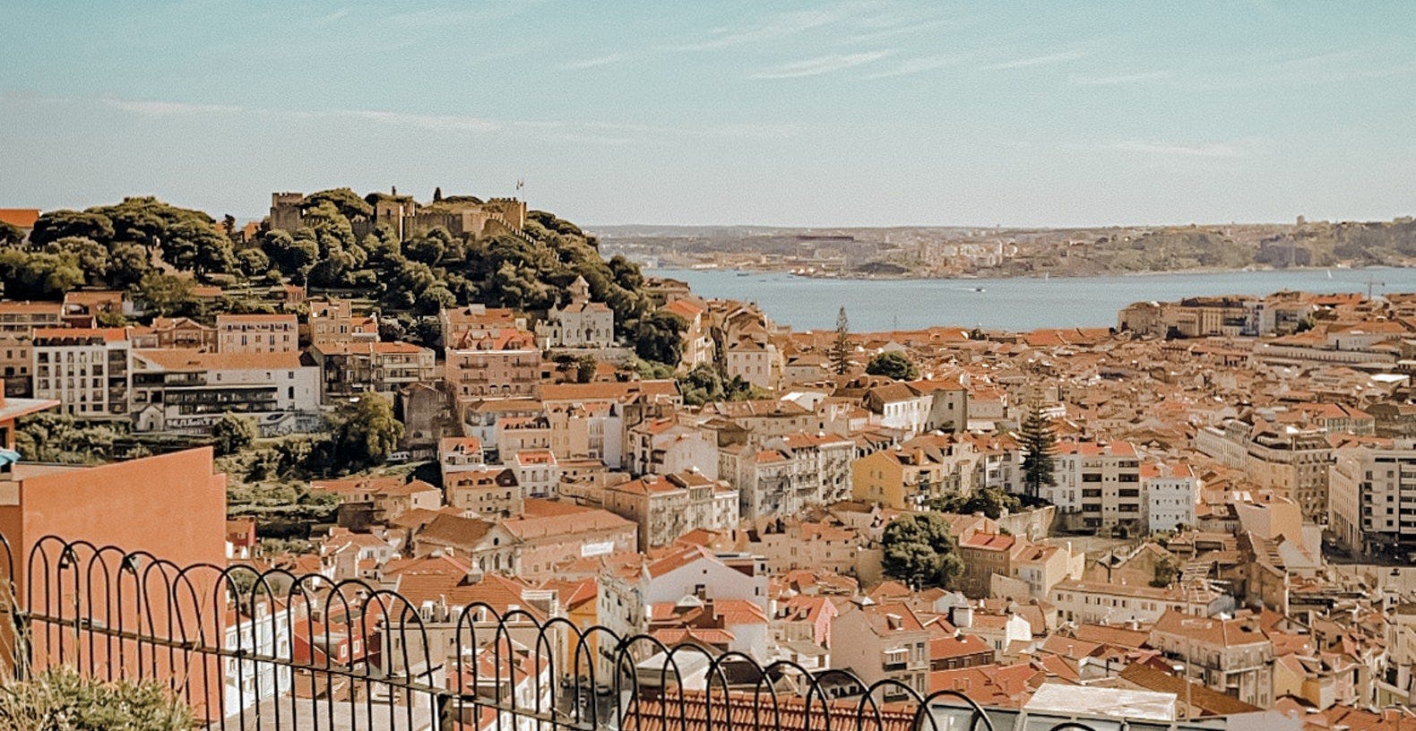 Aussicht über Lissabon von einem Aussichtspunkt in Alfama mit vielen Häuern und dem Meer