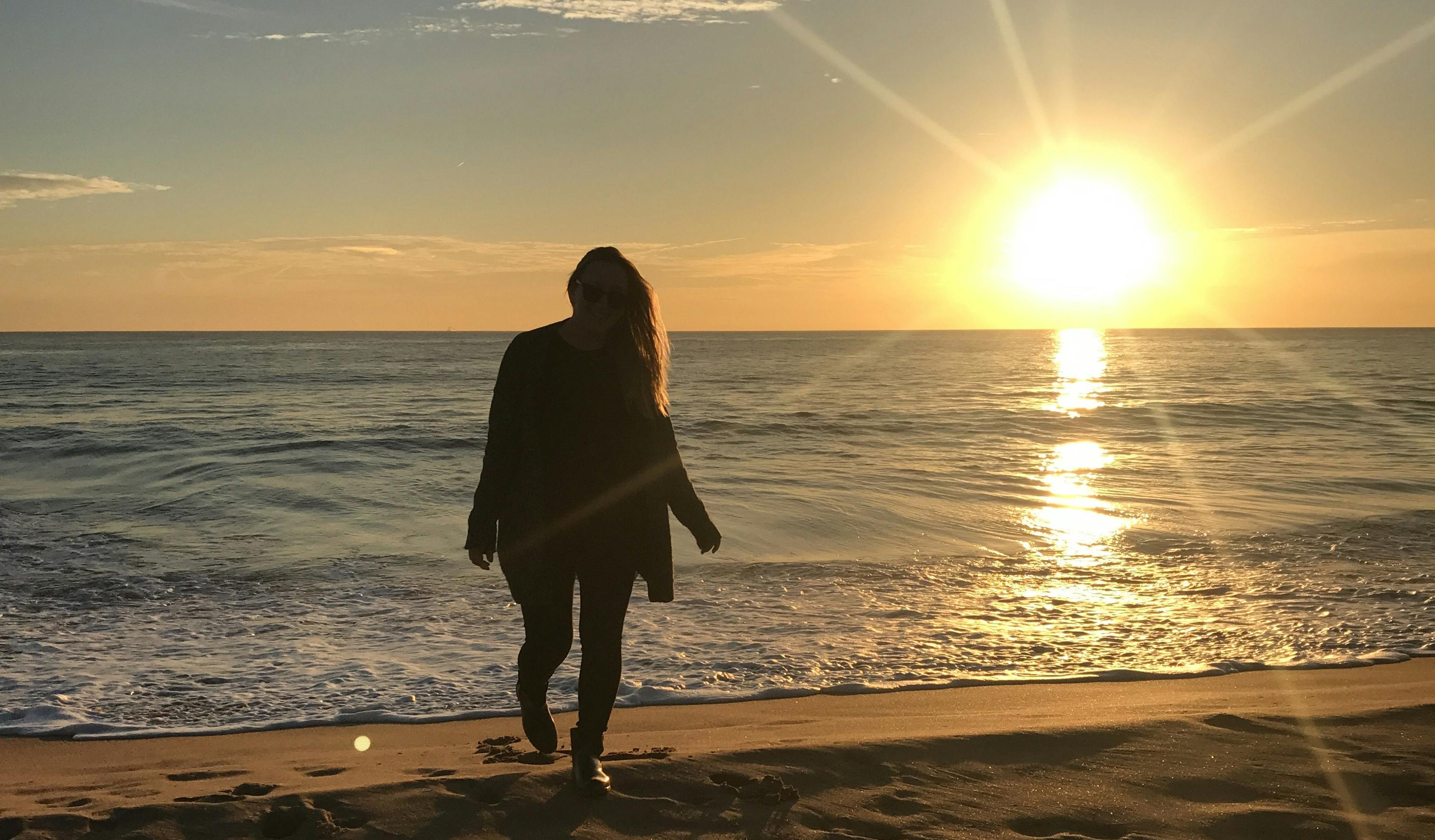Mädchen am Strand in Lissabon bei Sonnenuntergang