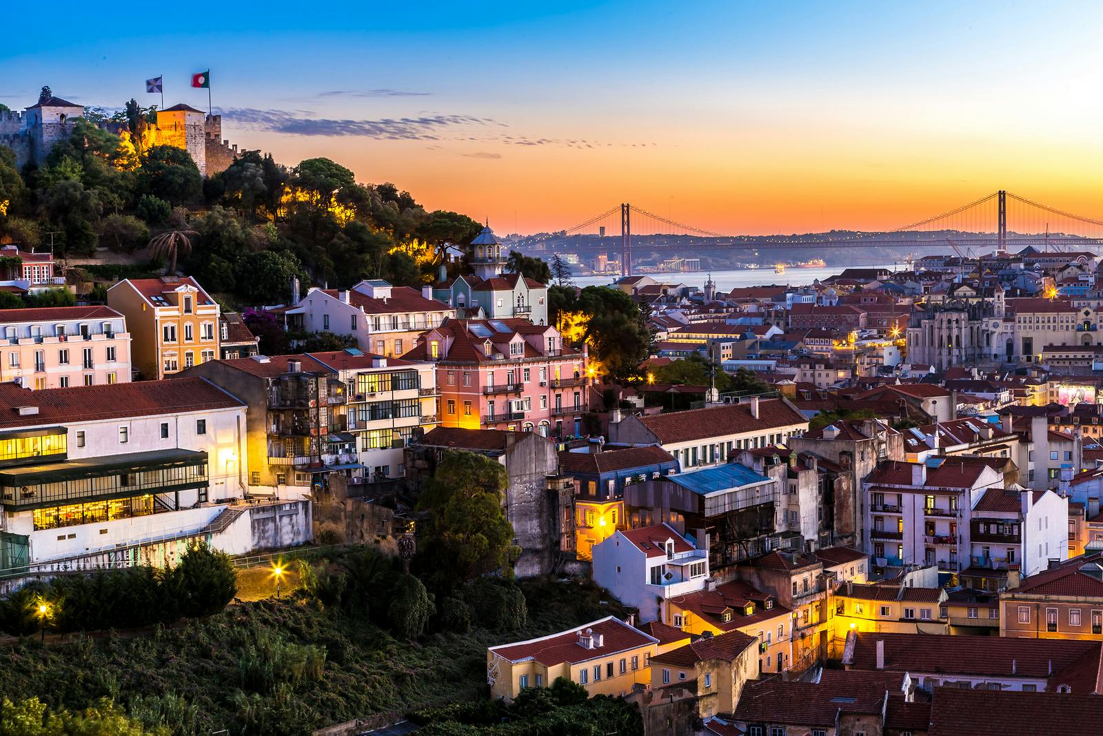 Viewpoint lisbon portugal coloured houses and sunset and Taag river and bridge