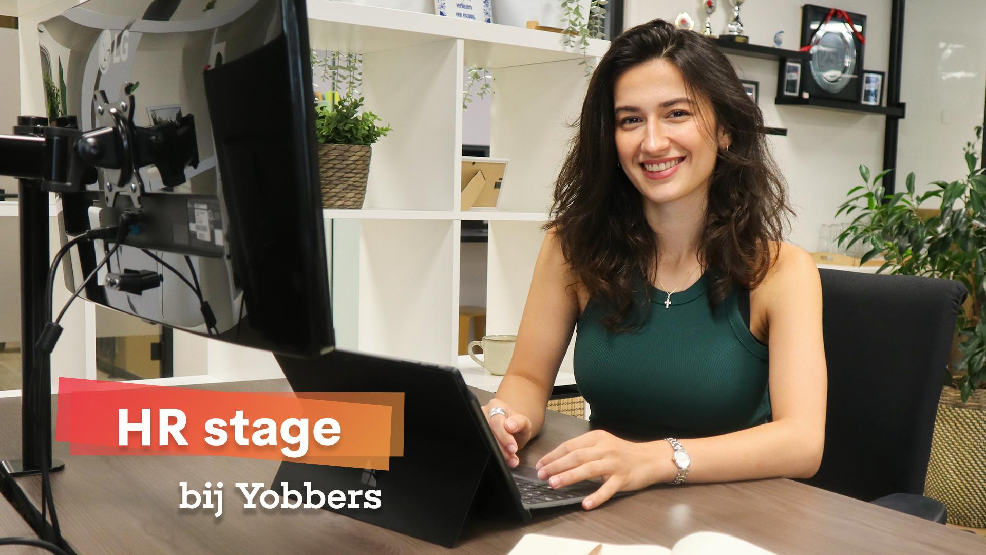 Lachend meisje aan het werk achter de computer in een kantoor