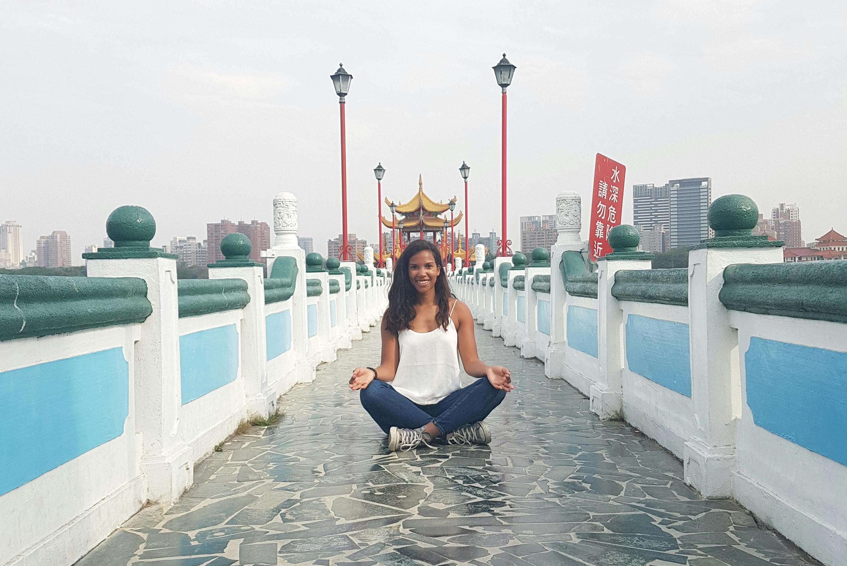 Vrouw in meditatie houding op een brug in Taiwan