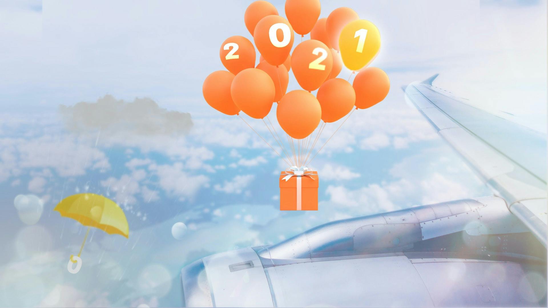 orangenes Paket mit Luftballons über den Wolken neben einem Flugzeugflügel