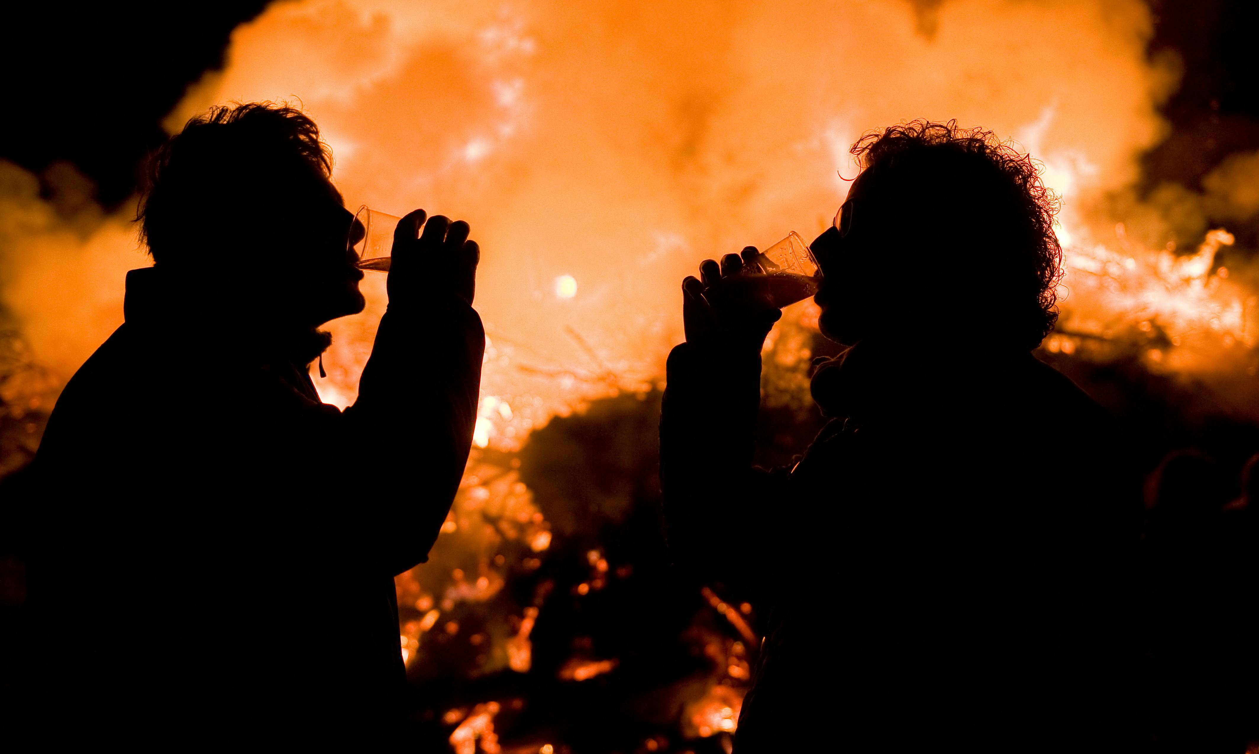 Two men drinking near the bonfire