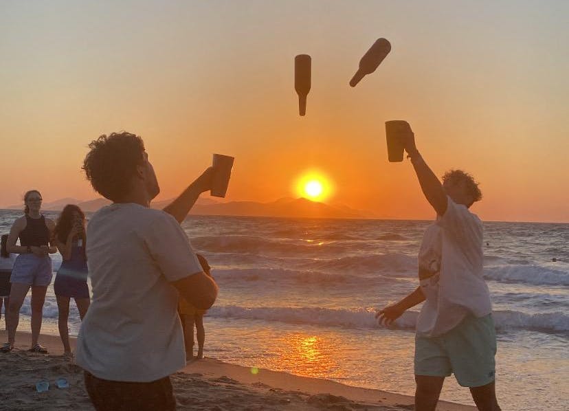 zwei Jungs spielen an Strand beim Sonnenuntergang in Kos