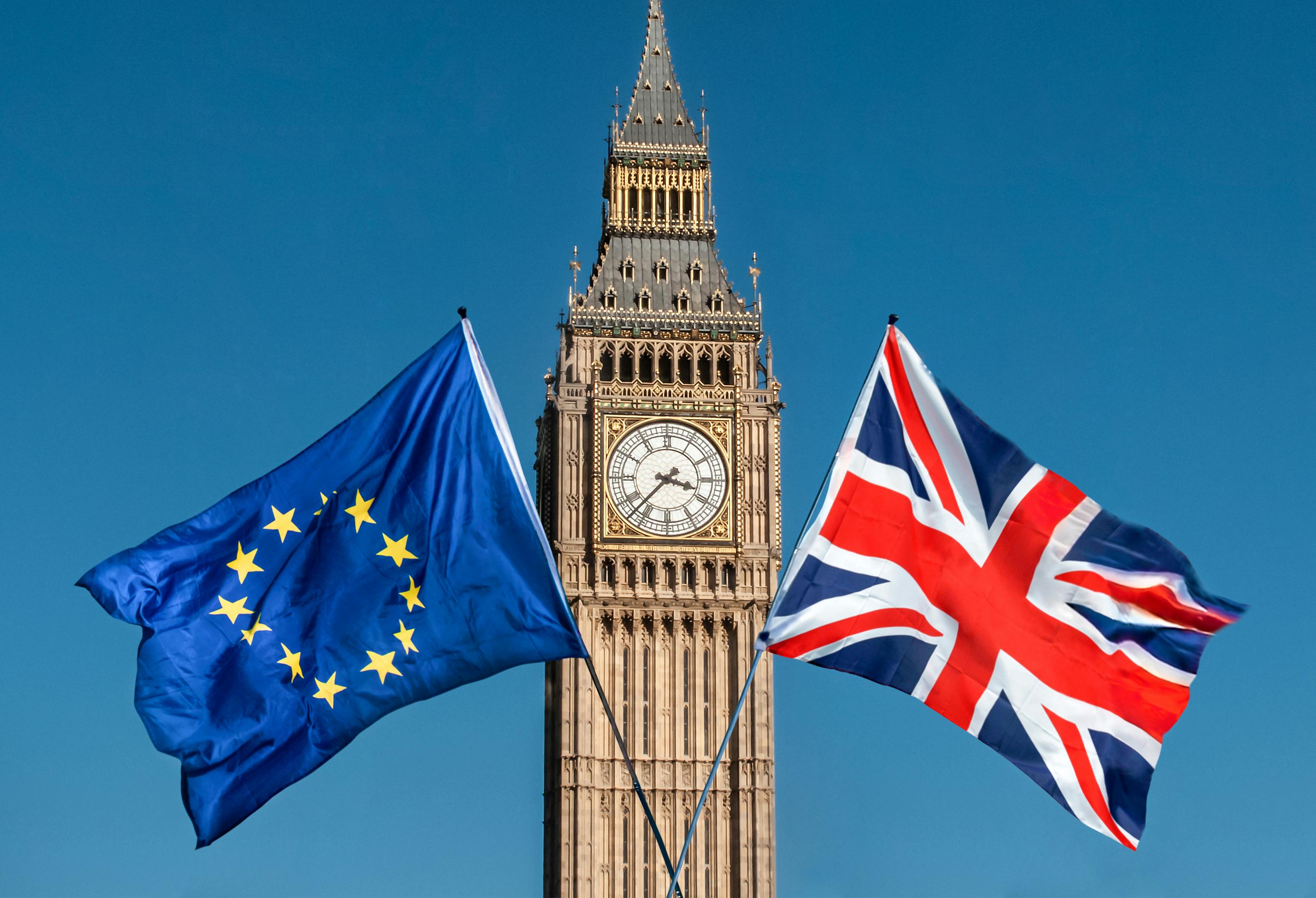 Flag of Great Britain and Europe flying in the sun after Brexit and Big Ben
