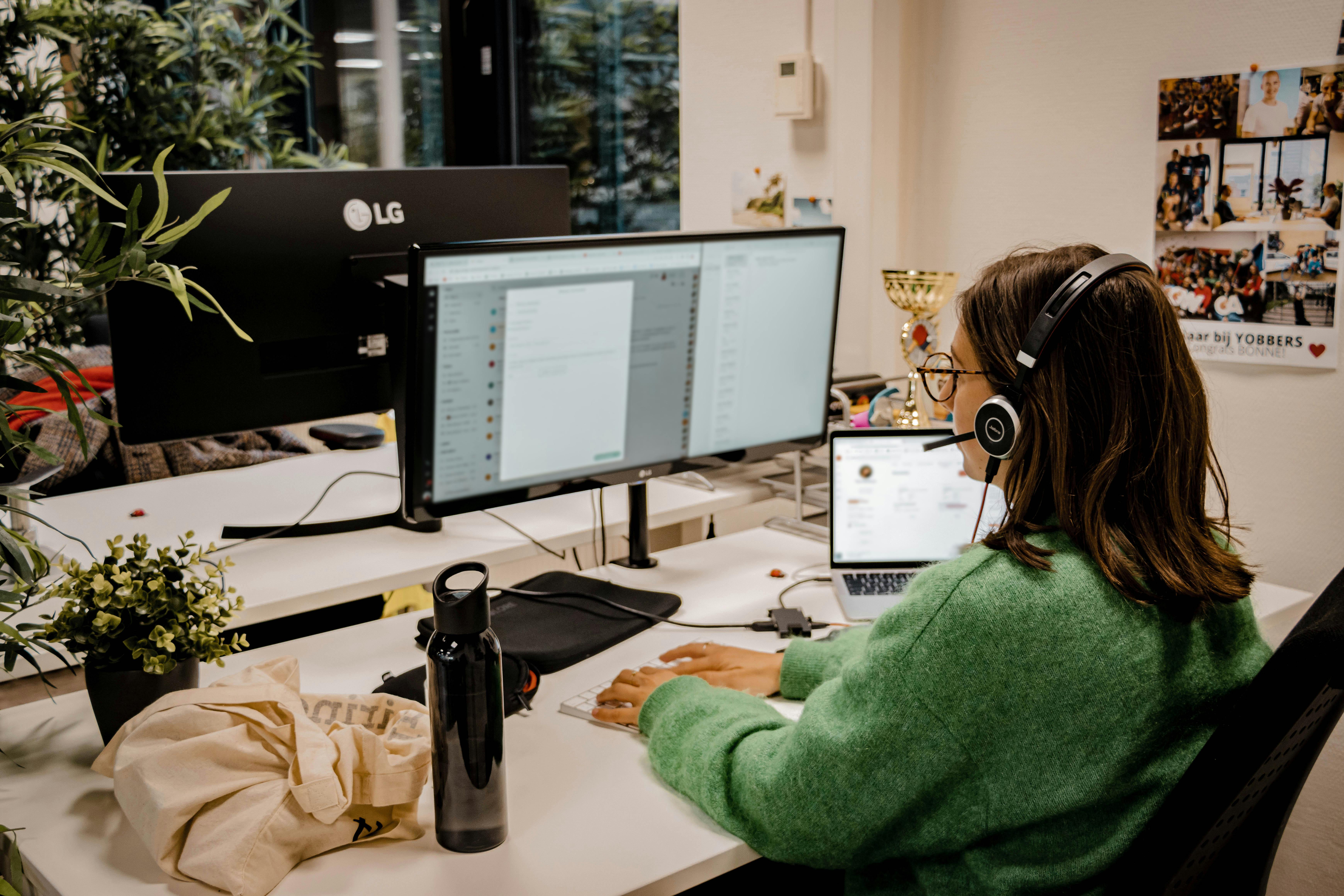 Working on a desk behind a laptop and computer recruiter calling