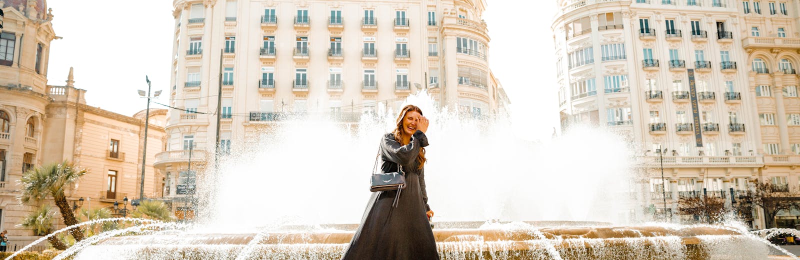 building and fountain with girl in long black dress