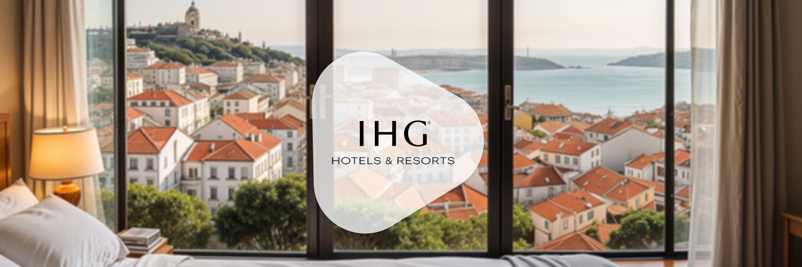 ihg logo vor einem fenster mit ausblick auf lissabon