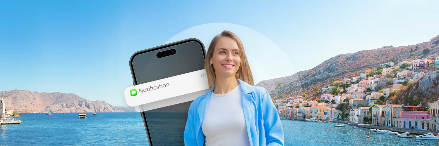 Lächelnde Frau draußen am Meer mit einem Smartphone im Vordergrund und einer Benachrichtigung.