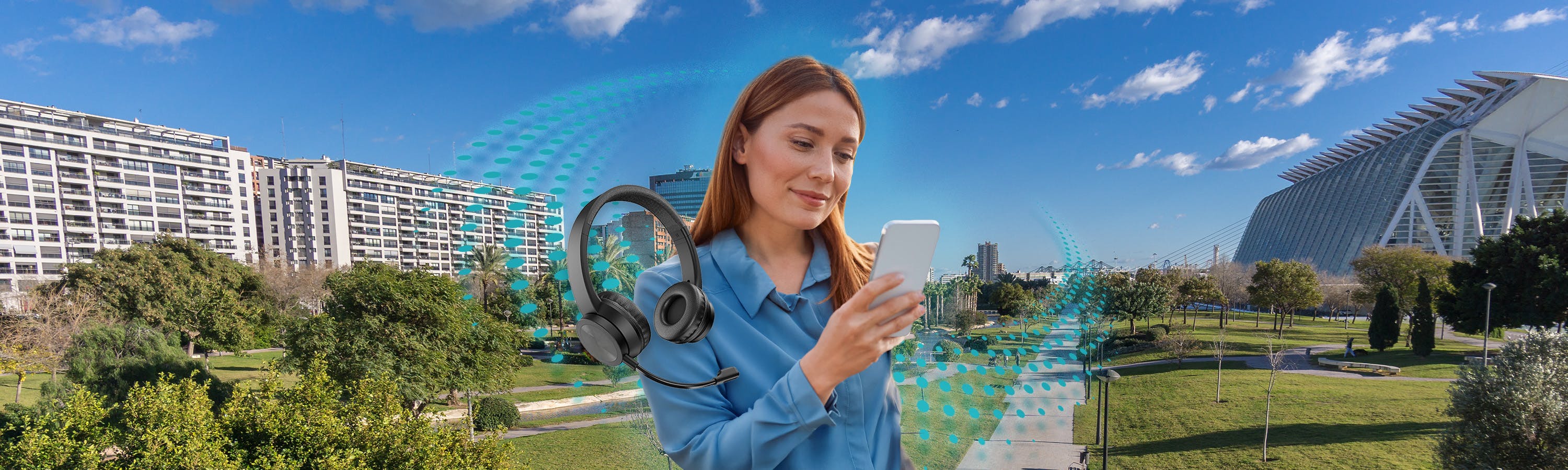 Woman on phone next to black headphones and a park in the background